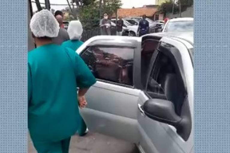 Pessoas de verde e toca em frente a um carro