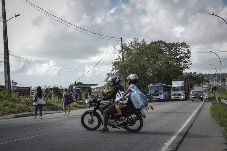 Pedestres e motociclista atravessam a rodovia em meio a veículos em alta velocidade