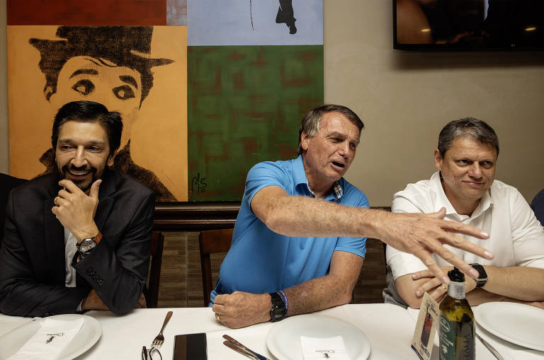 Fotografia mostra o prefeito Ricardo Nunes ao lado do ex-presidente Jair Bolsonaro e do governador Tarcísio de Freitas em uma pizzaria