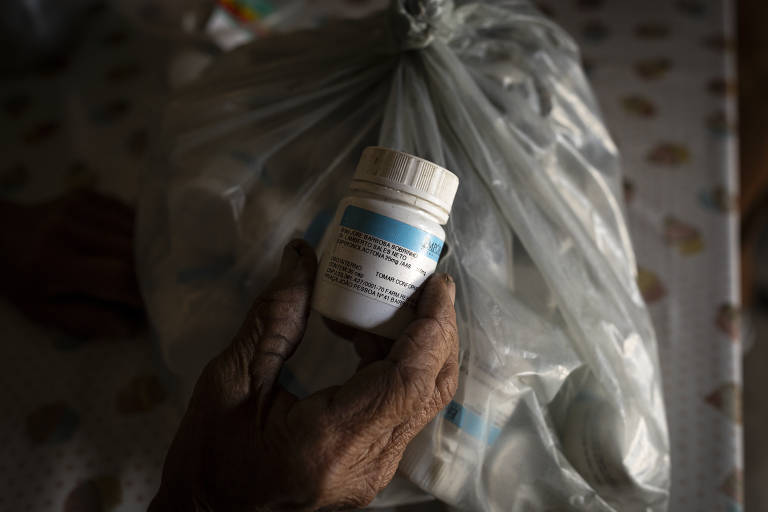 Alzira Maria da Conceição (81), mostra um remédio utilizado pelo marido