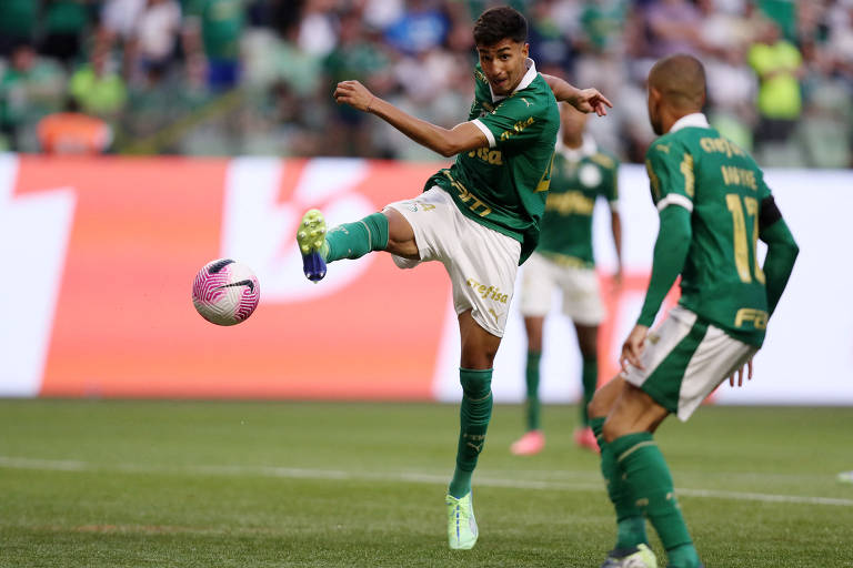 Fotografia mostra o jogador Vitor Reis chutando uma bola de futebol durante partida contra o Fortaleza. Ele usa calção branco, camisa e meias verdes