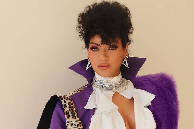 Em foto colorida, mulher aparece vestida com uma fantasia em homenagem ao cantor Prince