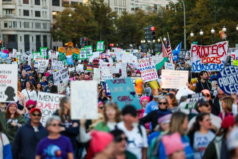 Imagem mostra centenas de pessoas carregando cartazes na Marcha Nacional das Mulheres em Washington, DC, a poucos dias das eleições presidenciais nos Estados Unidos.