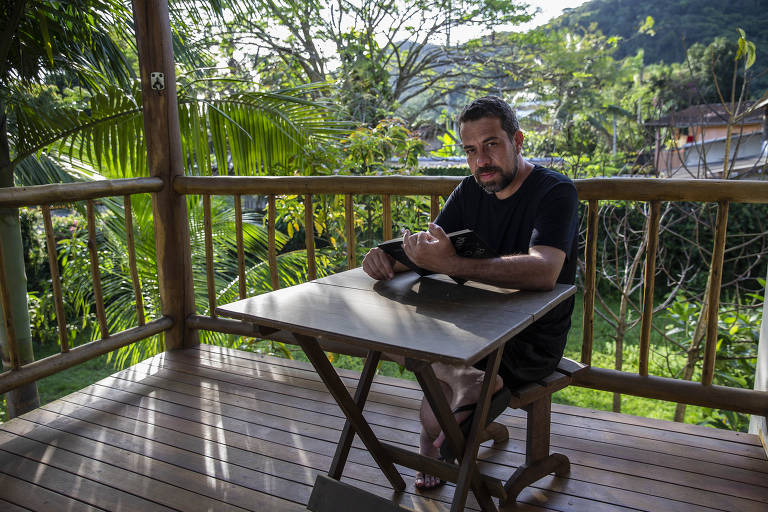 O deputado federal Guilherme Boulos (PSOL), que foi candidato à Prefeitura de São Paulo, lê durante a sua estadia na praia após o segundo turno
