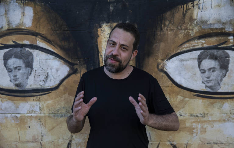 O deputado federal Guilherme Boulos (PSOL), que foi candidato à Prefeitura de São Paulo, em frente a grafite com rosto de Frida Kahlo pintado
