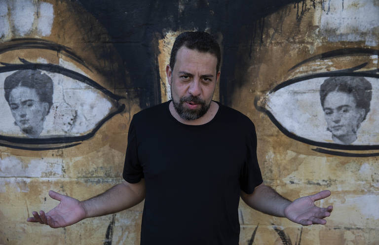 O deputado federal Guilherme Boulos (PSOL), que foi candidato à Prefeitura de São Paulo, em frente a grafite com rosto de Frida Kahlo pintado
