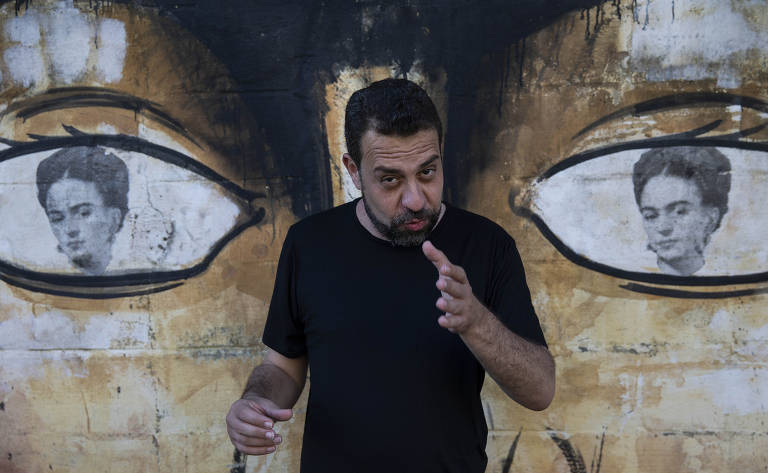 O deputado federal Guilherme Boulos (PSOL), que foi candidato à Prefeitura de São Paulo, em frente a grafite com rosto de Frida Kahlo pintado