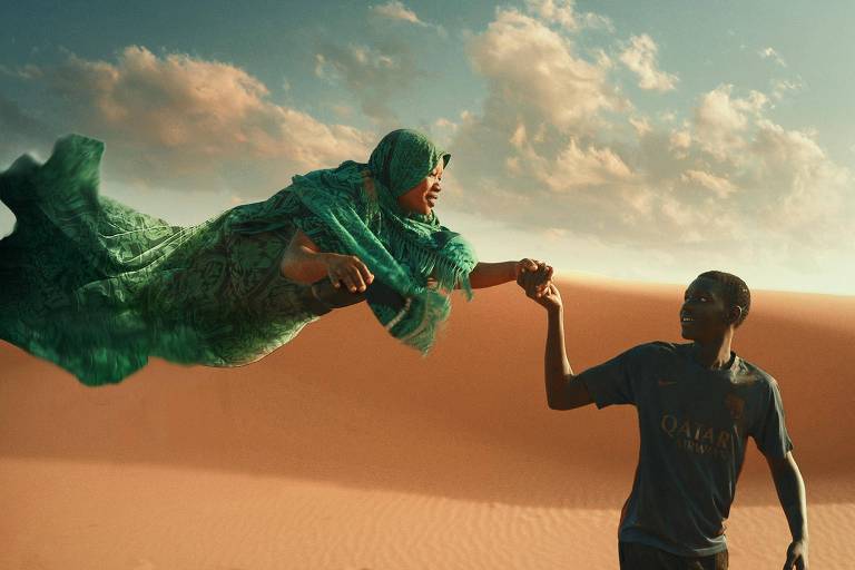 A imagem mostra uma mulher vestida com um manto verde, flutuando sobre um deserto, segurando a mão de uma criança que está em pé na areia. O céu é azul com nuvens brancas, e as dunas de areia são visíveis ao fundo.