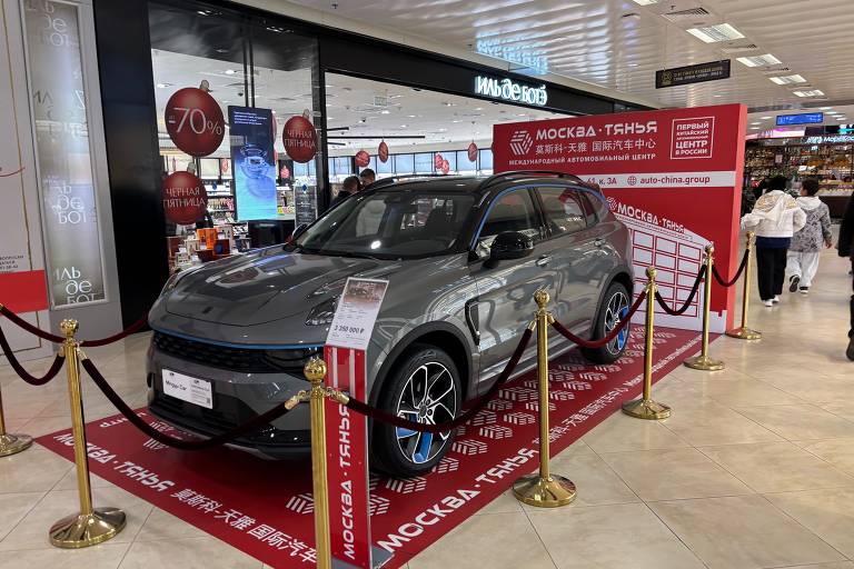 Carro cinza em estande vermelho no corredor de um shopping