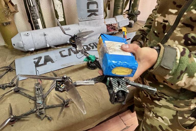 Soldado mostra drone ucraniano capturado com sua bateria