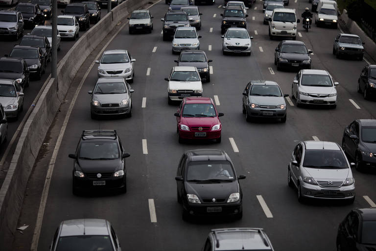 Imagem de vários carros na Marginal Pinheiros em São Paulo. No centro da imagem， um carro vermelho se destaca entre veículos de cores mais comuns， como branco， preto e prata