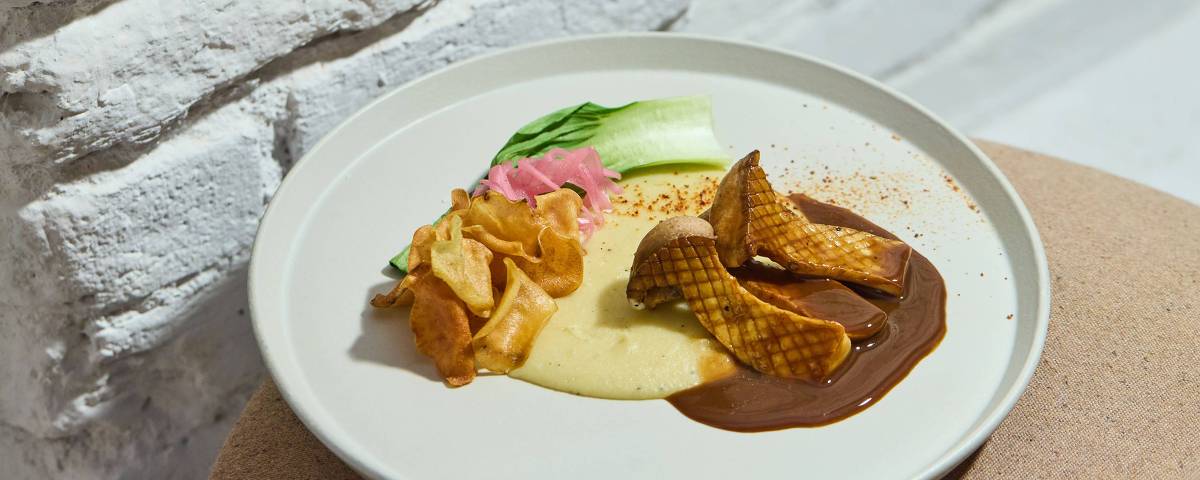 Eryngui com mousseline, glace de cogumelos e bok choy, prato do Tau Cozinha, na Vila Madalena