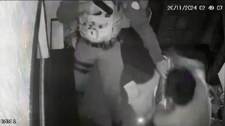 Um policial aparece na sequência, dá alguns passos na escada e puxa Marco Aurélio Cardenas Acosta, 22, pelo braço