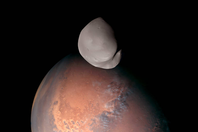 Uma foto sem data fornecida pela Emirates Mars Mission mostra uma imagem composta de Deimos, capturada pela Emirates Mars Mission, sobre Marte. Novas imagens de alta resolução do minúsculo Deimos tiradas por um orbitador dos Emirados sugerem que pode não ser o asteróide capturado que os cientistas disseram que era.