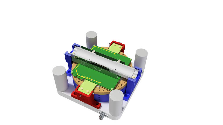 A imagem mostra um modelo tridimensional de um dispositivo eletrônico. O dispositivo possui uma base circular com componentes eletrônicos visíveis, incluindo uma placa verde e várias partes coloridas em vermelho e azul. Há também cilindros brancos ao redor da base, e um componente longo e reto na parte superior. O fundo é branco, destacando o dispositivo.