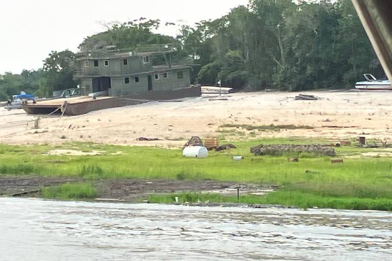 Barco encalhado em praia formada após seca na região