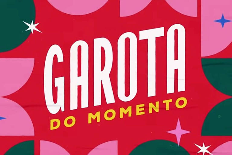 A imagem apresenta um fundo colorido com formas geométricas em tons de verde, rosa e vermelho. No centro, está o texto 'GAROTA' em letras brancas e 'DO MOMENTO' em letras amarelas, ambos em uma fonte estilizada. O design inclui estrelas brancas e rosa, adicionando um toque decorativo ao fundo vibrante.