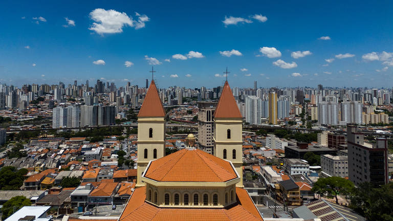 À frente, a Basílica da Penha; cercada de vários edifícios no bairro da zona leste