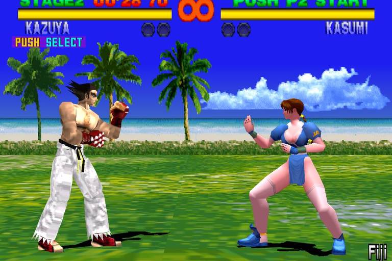 A imagem mostra dois personagens de um jogo de luta em um cenário tropical. À esquerda, um lutador masculino chamado Kazuya, com cabelo preto e roupas brancas, está em uma pose de combate. À direita, uma lutadora feminina chamada Kasumi, vestindo um traje azul, também está em uma posição de luta. Ao fundo, há palmeiras e um céu azul com nuvens, sugerindo um ambiente de praia. Na parte superior da imagem, há informações sobre o estágio e o tempo restante.