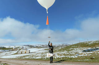 Penny Smale, NIWA Atmospheric Technician, launches an atmospheric balloon at the station near Lauder, Central Otago, New Zealand, Sept. 14, 2024. (Tatsiana Chypsanava/The New York Times)