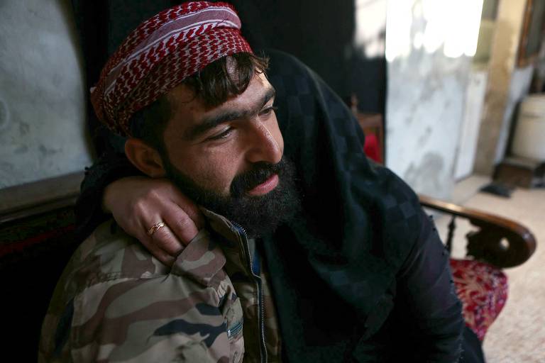 Mulher abraça o filho após anos separados, após a queda de Aleppo para rebeldes