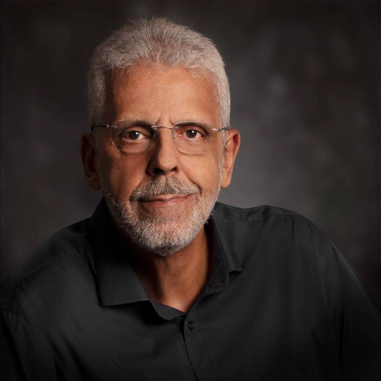 Homem com cabelo e barba branca， com óculos e camisa preta