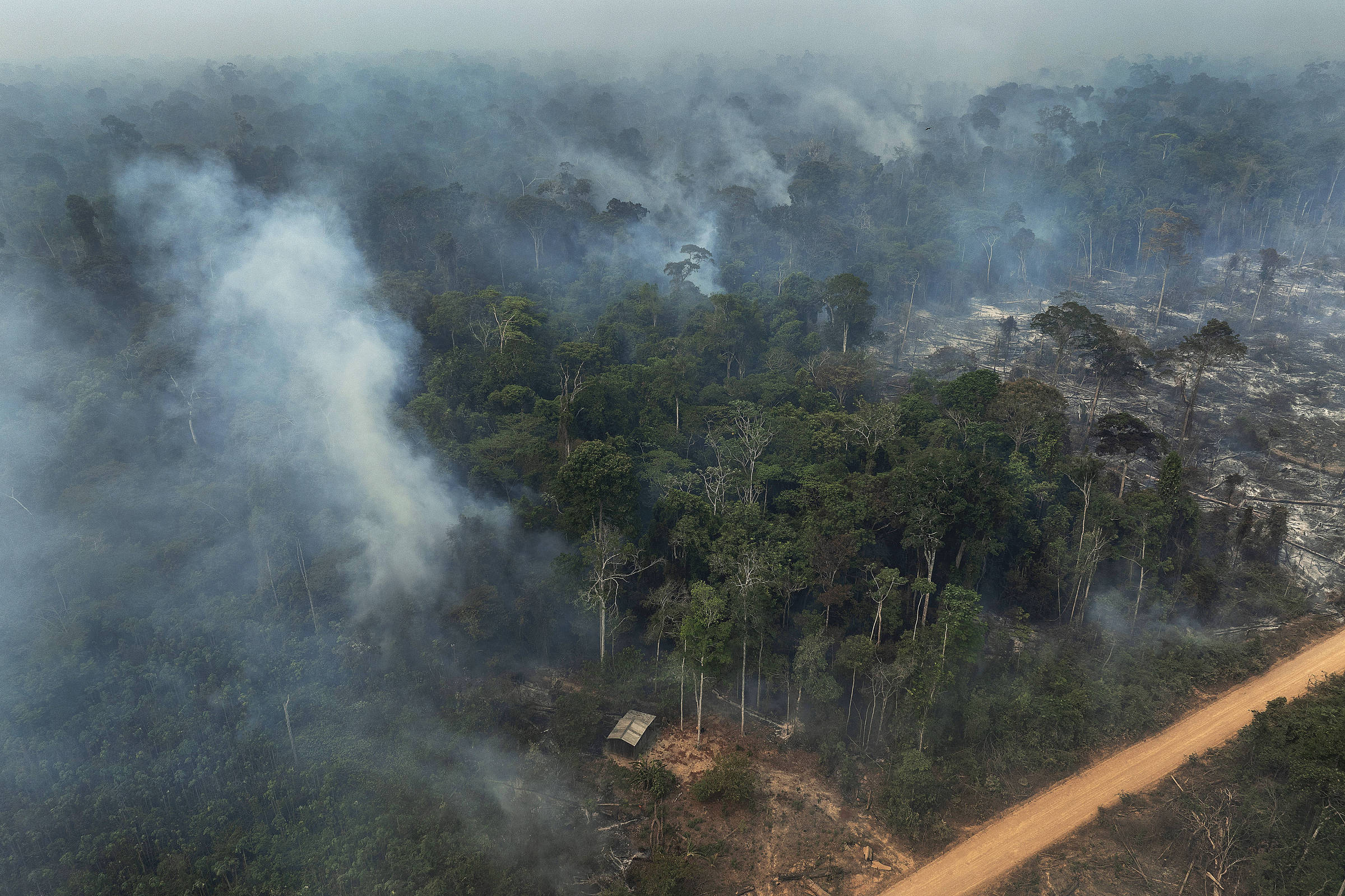 Fumaça de queimada, vista de cima, se aproxima de casa