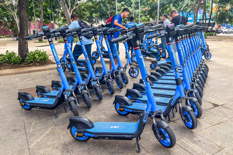Dezenas de patinetes elétricas na cor azul em praça