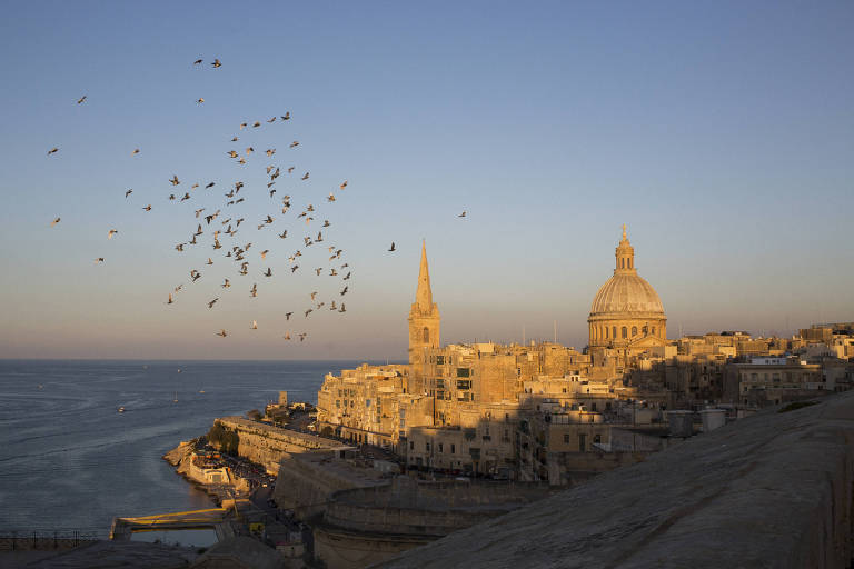 Pássaros voam sobre o horizonte de Valletta， Malta