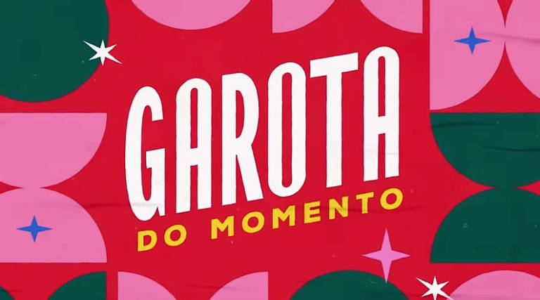 A imagem apresenta um fundo colorido com formas geométricas em tons de verde, rosa e vermelho. No centro, está o texto 'GAROTA' em letras brancas e 'DO MOMENTO' em letras amarelas, ambos em uma fonte estilizada. O design inclui estrelas brancas e rosa, adicionando um toque decorativo ao fundo vibrante.