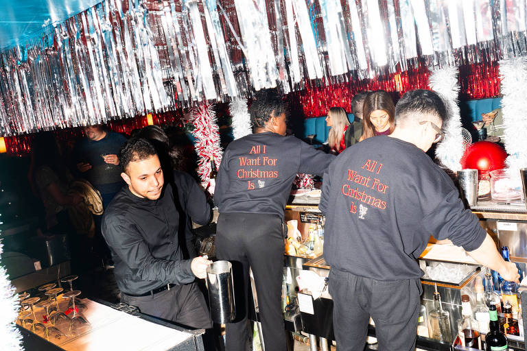 Pessoas vestindo roupas pretas trabalham num bar