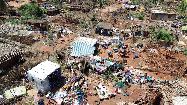 Pessoas ficam no meio de prédios destruídos e árvores arrancadas após o ciclone Chido atingir Moçambique