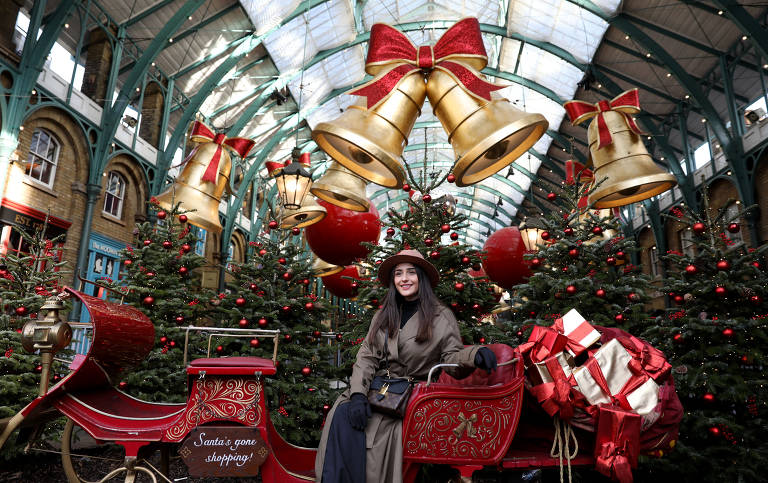 Mulher posa para fotos com decorações de Natal no Mercado de Covent Garden, em Londres