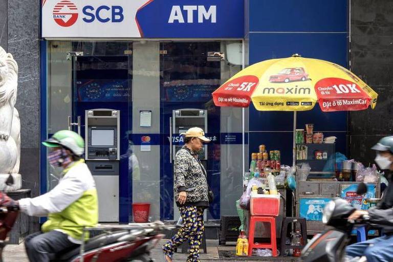 Motocicletas passando por uma agência do Saigon Commercial Bank (SCB) na cidade de Ho Chi Minh, no Vietnã