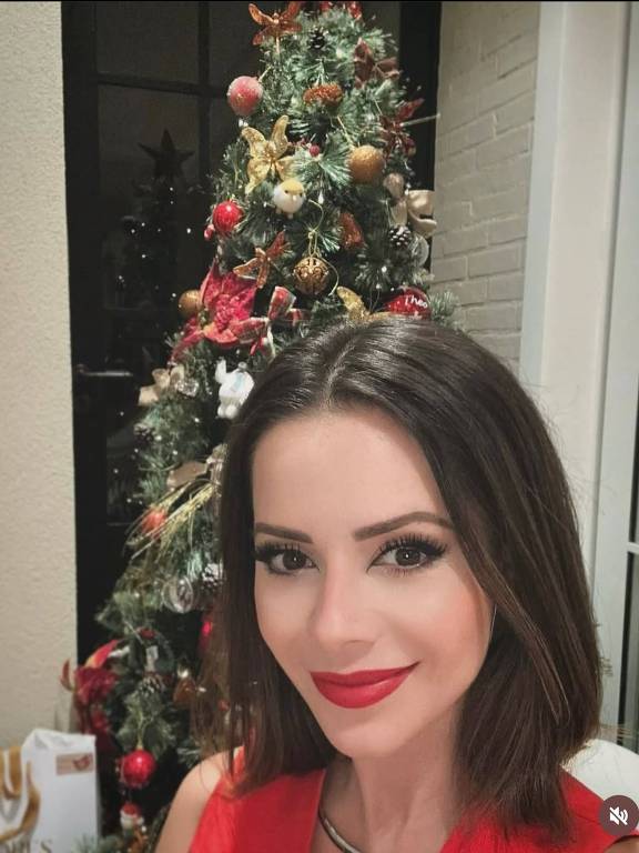 Mulher de cabelo preto com árvore de natal