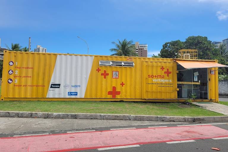 Container amarelo com sinais vermelhos de soma da startup So+ma