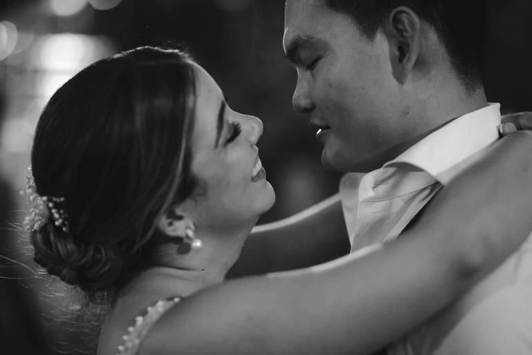 Foto em preto e branco de Nay e Dam no dia do casamento. Estão abraçados e se olhando, sorrindo