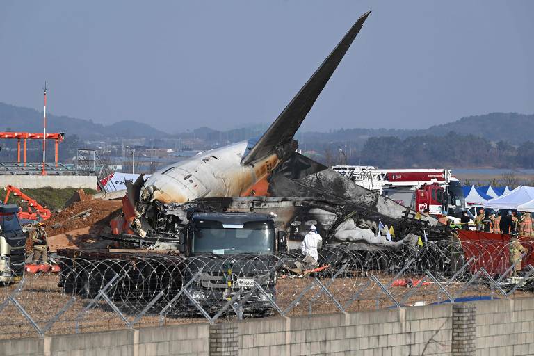 Foto mostra equipe de resgate trabalhando nos destroços do Boeing 737-800 que explodiu na Coreia do Sul.