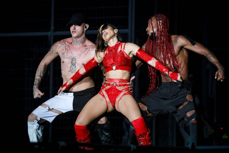 Em foto colorida, mulher de vermelho aparece no palco