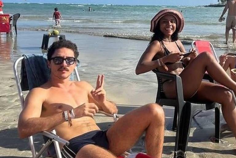 Em foto colorida, casal curte praia no último dia do ano em 2024