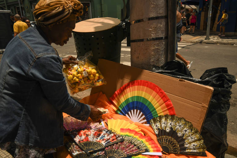 Mulher ao lado de mesa com leques coloridos