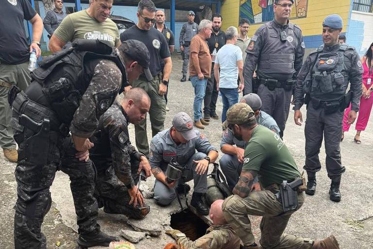 Imagem mostra policiais civis e militares próximos a um buraco