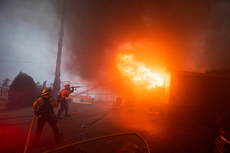 Imagem mostra bombeiros combatendo incêndio em casa， que está completamente em chamas