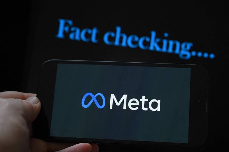 A imagem mostra um smartphone segurado por uma mão， exibindo o logotipo da Meta em um fundo escuro. Acima do smartphone， há um texto em azul que diz 039;Fact checking....039;.