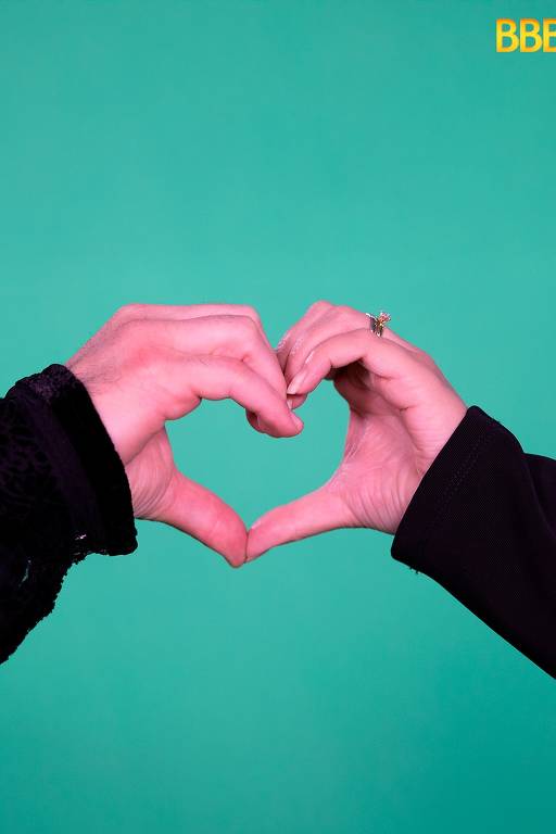 Duas mãos estão unidas formando a forma de um coração. A mão à esquerda é masculina, com um anel visível, e a mão à direita é feminina, também com um anel. O fundo é verde liso. No canto superior direito, há um logotipo que diz 'BBBO'.