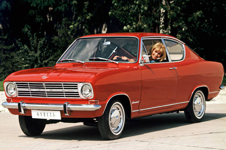 Opel Kadett B versão cupê de frente com mulher ao volante; esta geração foi produzida pela montadora entre 1965 e 1970