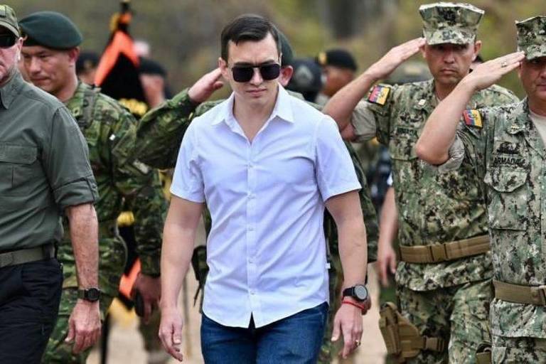 Daniel Noboa caminha entre militares que batem continência.