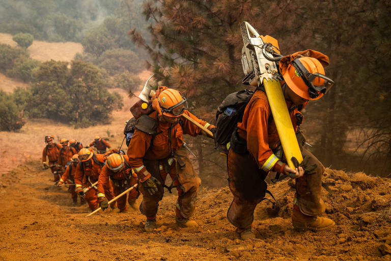 FILE --Inmate firefighters clearing a fire line on the Walbridge Fire near Healdsburg， Calif.， during the LNU Complex fire， Aug. 23， 2020. Hundreds of incarcerated people are firefighting in Los Angeles. They usually make up to $10.24 a day， and receive an additional $1 for each hour that they battle the deadly blazes. (Max Whittaker/The New York Times)