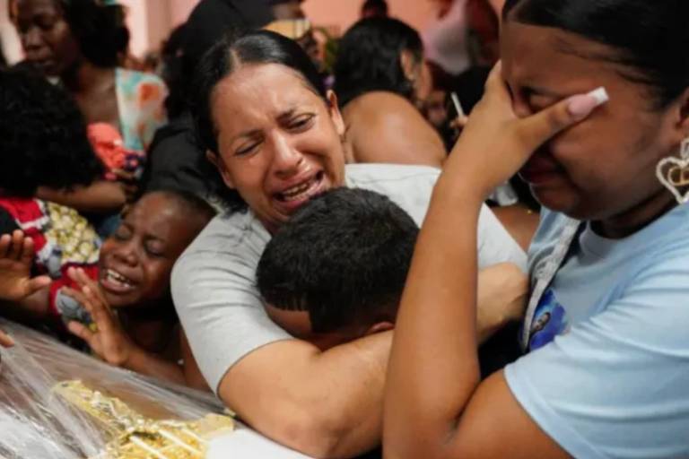 Parentes negros se abraçam e choram em funeral de meninos assassinados