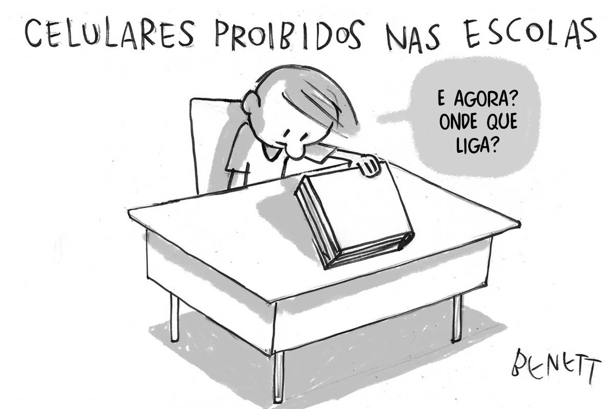 A charge de hoje publicada pela Folha em todas as suas plataformas é de Benett (@cartunistabenett). A imagem mostra um aluno sentado em uma carteira escolar, com um livro fechado na frente dele. O aluno parece confuso e está pensando em algo. Uma nuvem de pensamento sai da sua cabeça com a frase "E agora? Onde que liga?". Acima da imagem, há o título "Celulares proibidos nas escolas"